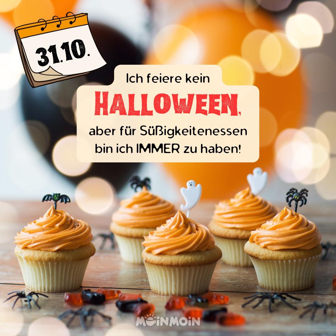 Fünf Cupcakes mit orangefarbener Glasur, dekoriert mit kleinen Geistern und Spinnen, stehen auf einem Tisch. Im Hintergrund sind unscharfe Halloween-Dekorationen zu sehen. Ein Kalenderblatt zeigt den 31. Oktober. Der Text auf dem Bild lautet: "Ich feiere kein Halloween, aber für Süßigkeitenessen bin ich IMMER zu haben!"